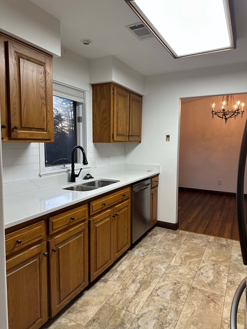 A kitchen with wooden cabinets and a tiled backsplash.