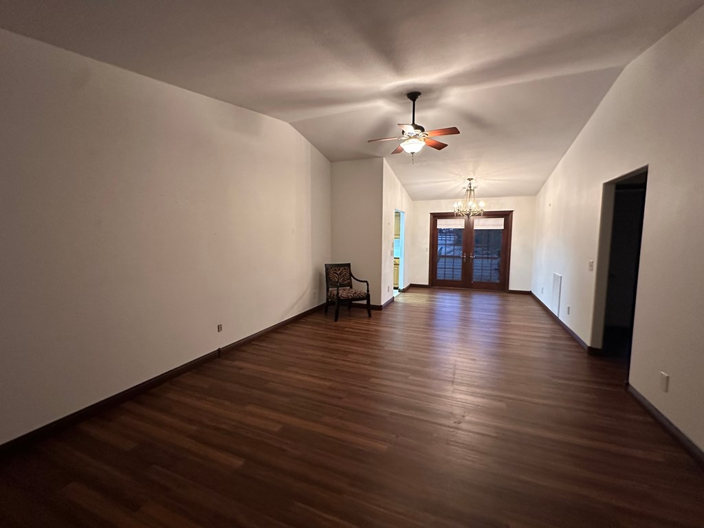 A room with wooden floors and a ceiling fan.