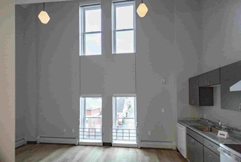 A kitchen with a sink, stove, and cabinets is shown.