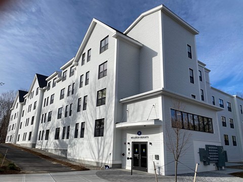 A white building with a black door and windows on the side.