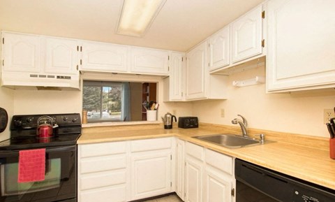 A kitchen with white cabinets and a black stove top oven.