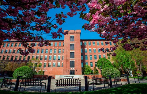 A red brick building with a black gate in front.