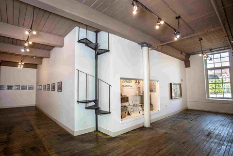 A room with a white wall and a wooden floor.