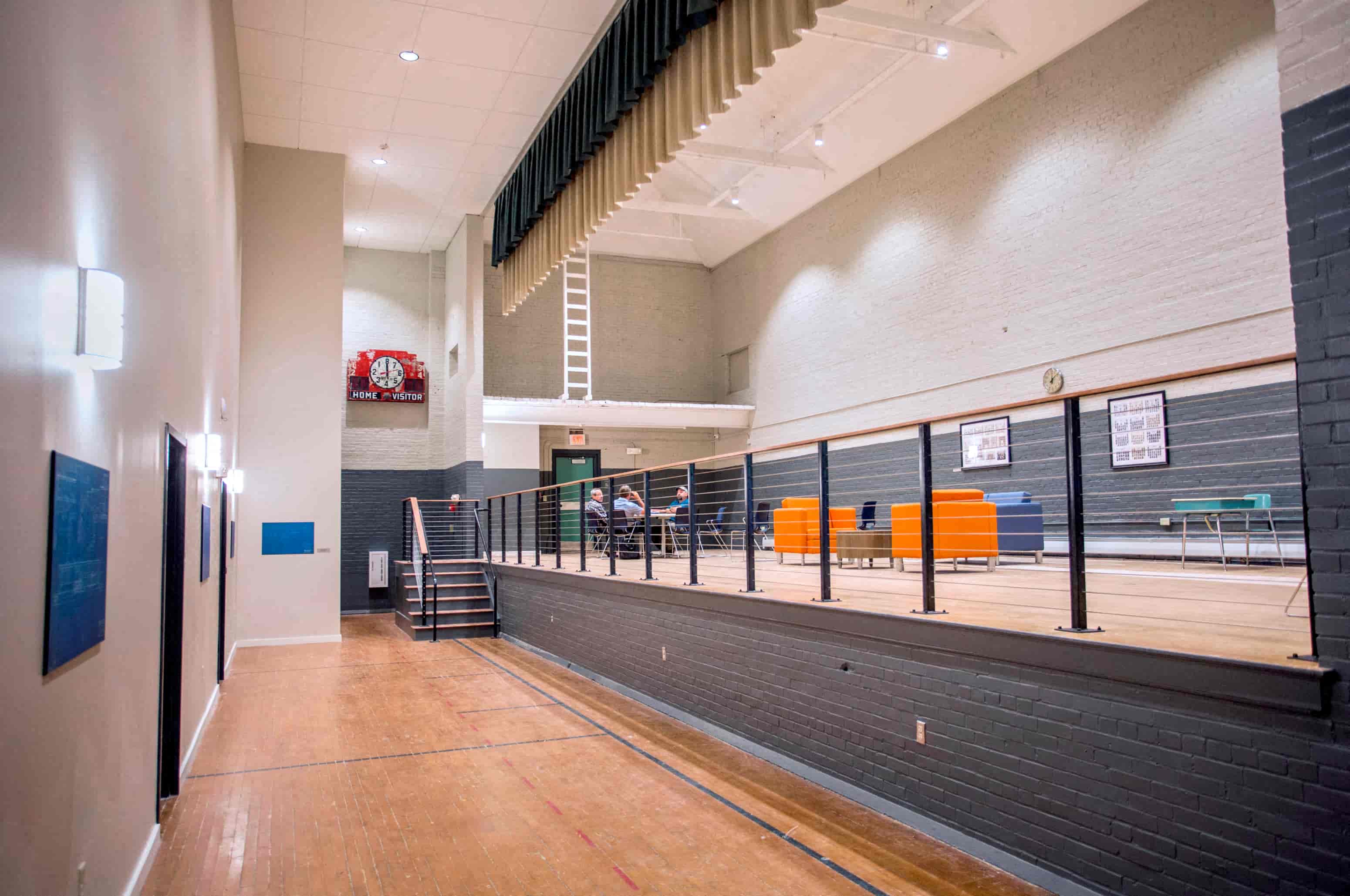 A long hallway with a basketball court at the end.
