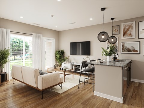 A modern kitchen and living room with a beige sofa and wooden floors.