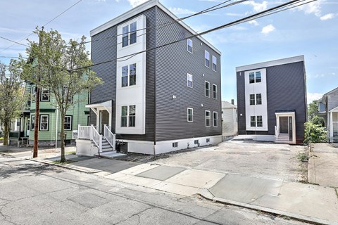 A row of modern townhouses with a clear blue sky above.