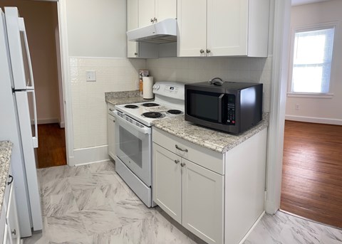 A kitchen with a white oven and microwave.