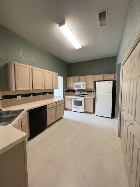 A kitchen with a white refrigerator and black dishwasher.