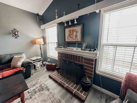 A living room with a fireplace and a painting above it.