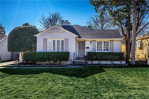 A house with a white front yard and a tree.
