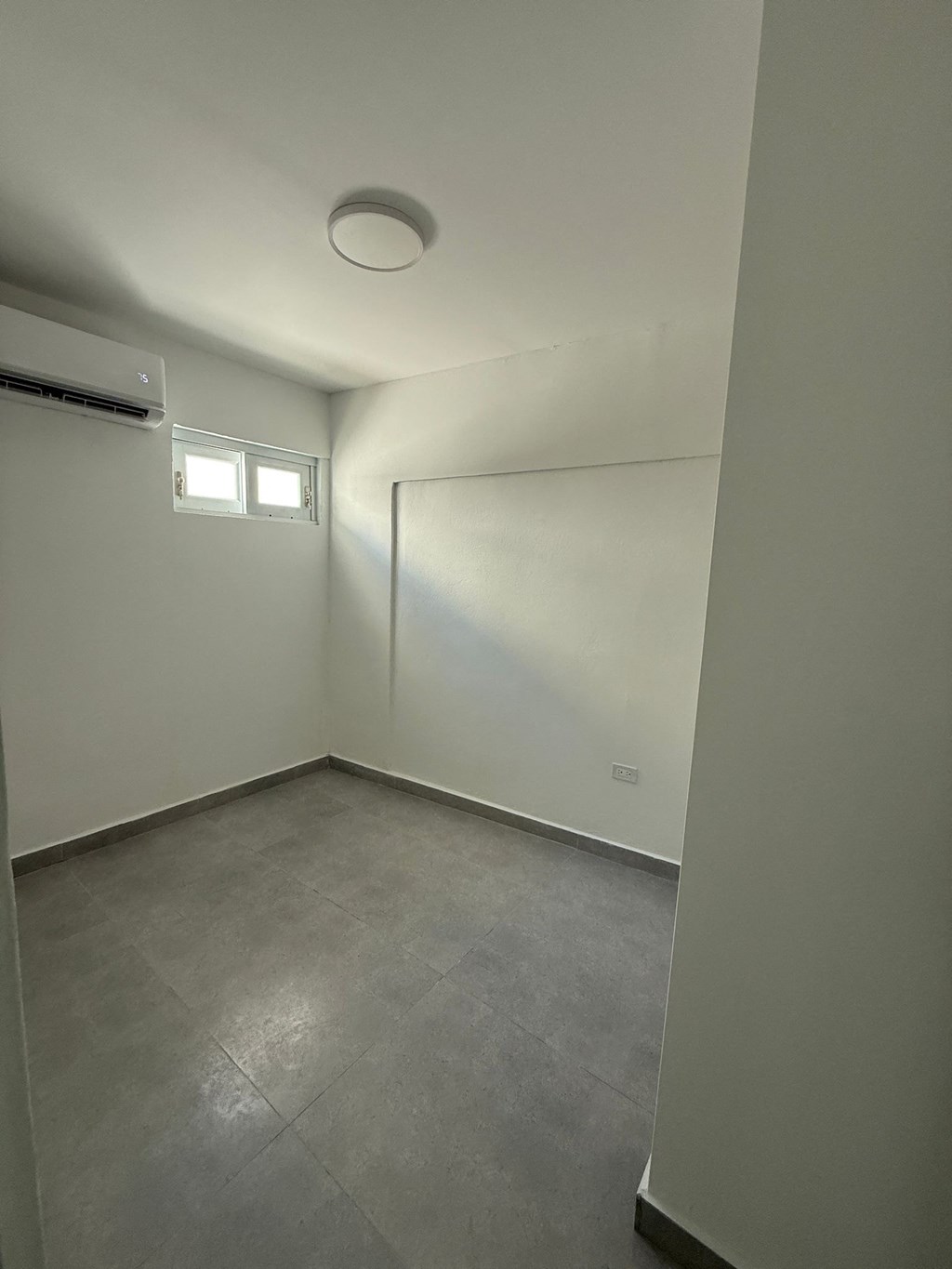 A room with a window and air conditioner.