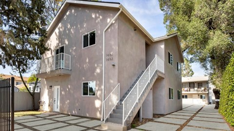 A two-story house with a balcony on the second floor.