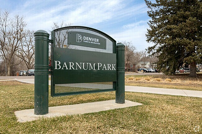 A sign for Barnum Park in Denver stands in a grassy area.