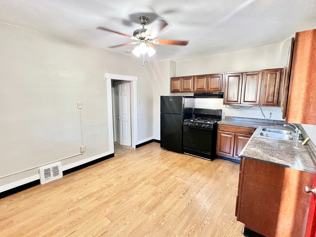 A wooden bench on a porch with green plants on the wall.