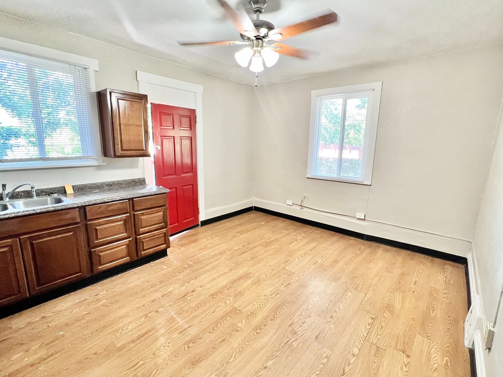 A wooden deck with a railing and a view of a wooded area.