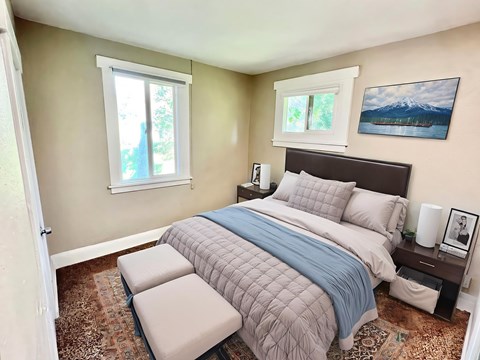 A bedroom with a large bed and a painting on the wall.