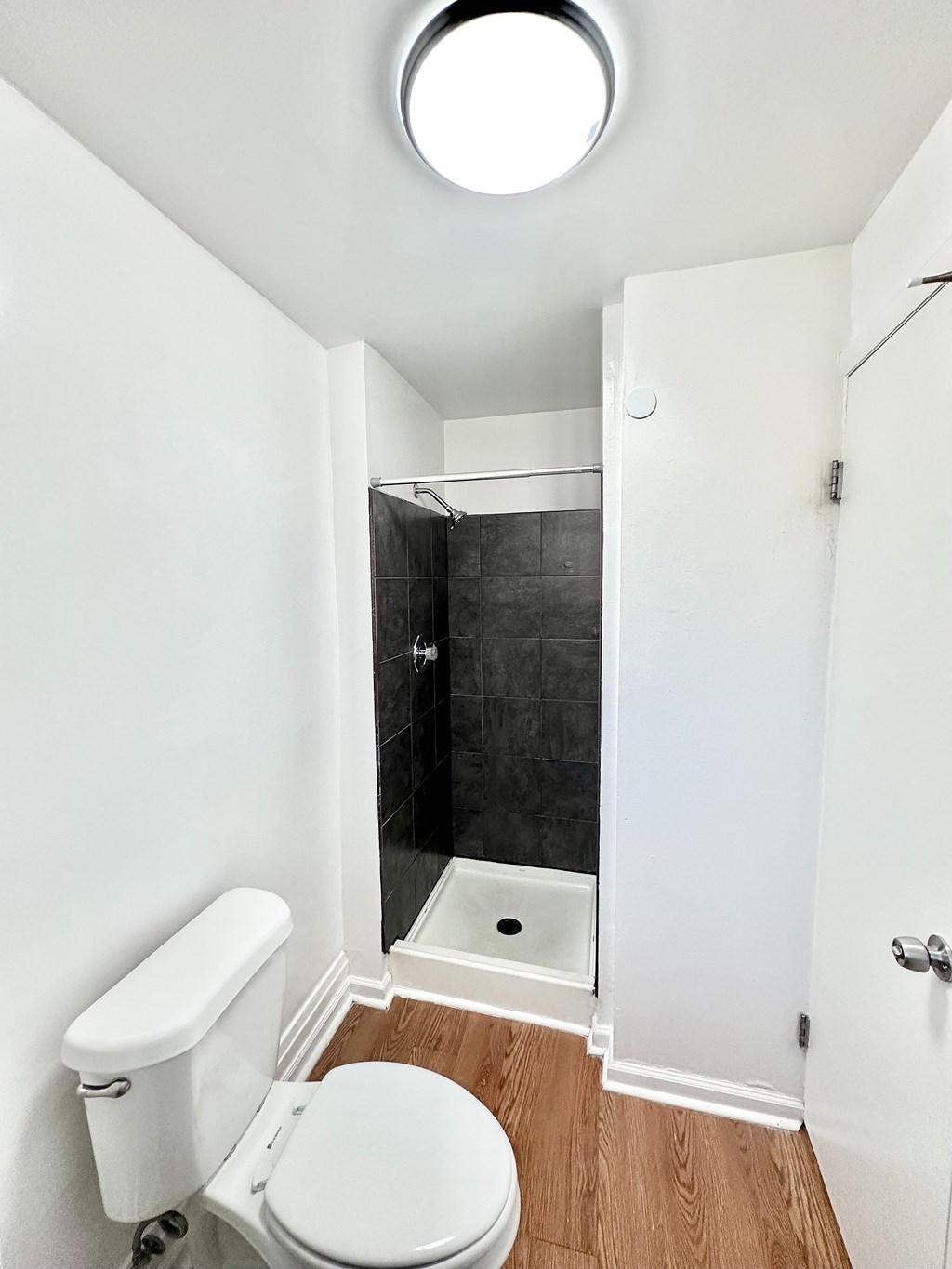 A red house with a balcony and a tree in the foreground.
