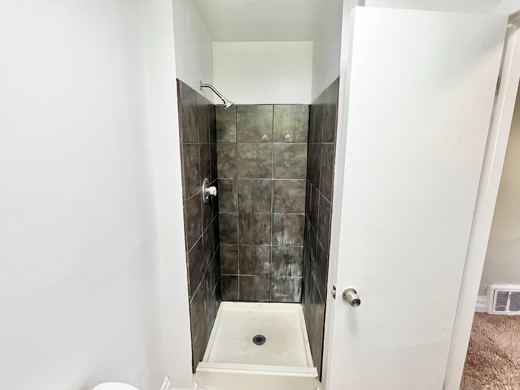A white bathroom with a walk in shower.