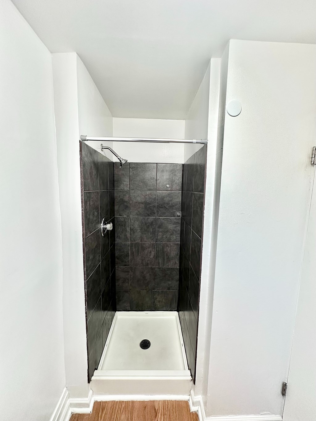 A small white bathroom with a walk in shower.