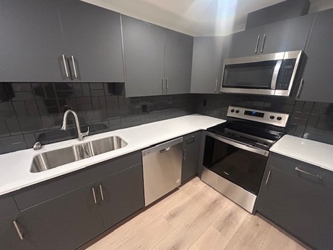A modern kitchen with a stainless steel sink and oven.