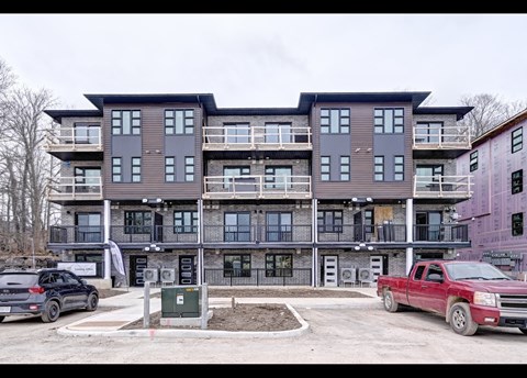 A large multi-story building with a parking lot in front.
