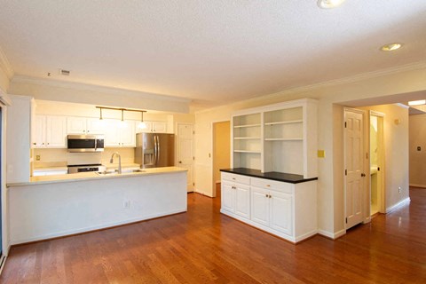 A kitchen with white cabinets and a black countertop.