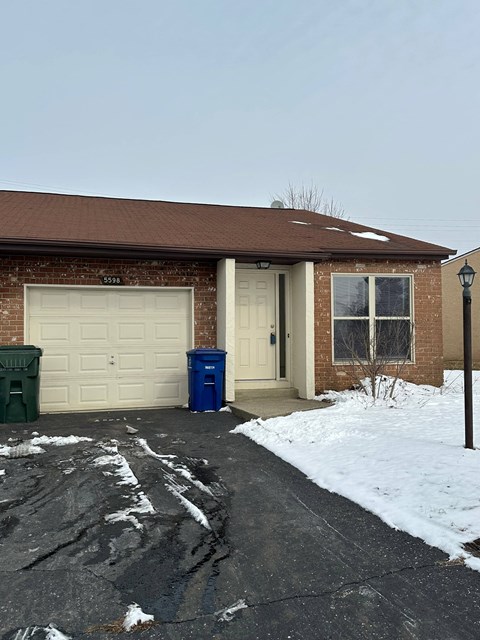A house with a brown roof and a white garage door.