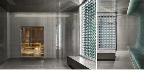 A modern bathroom with a glass block wall and a walk-in shower.