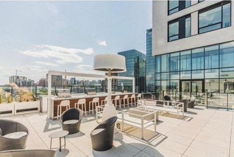 A rooftop patio with a table and chairs.