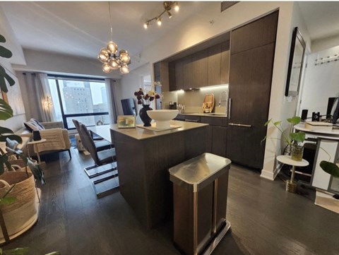 A modern kitchen with dark wood floors and a large island.