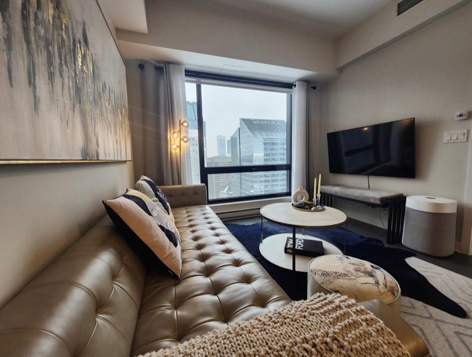A living room with a brown leather sofa and a white coffee table.