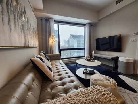 A living room with a brown leather sofa and a white coffee table.
