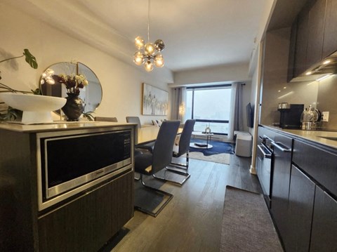 A modern kitchen with a black oven and a dining area with a table and chairs.