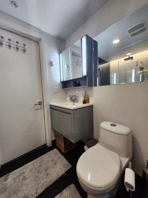A white toilet sits in a bathroom next to a white door.