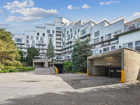 A parking lot in front of a white apartment building.