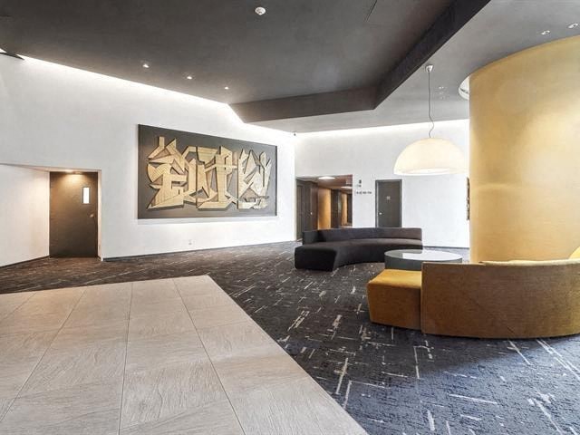 A large artwork hangs on the wall in a modern room.