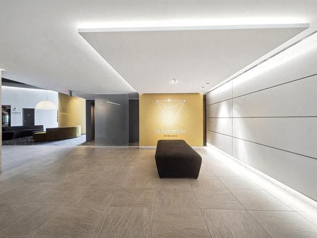 A hallway with a bench and a wall with a logo on it.