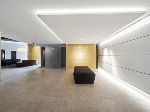 A hallway with a bench and a wall with a logo on it.
