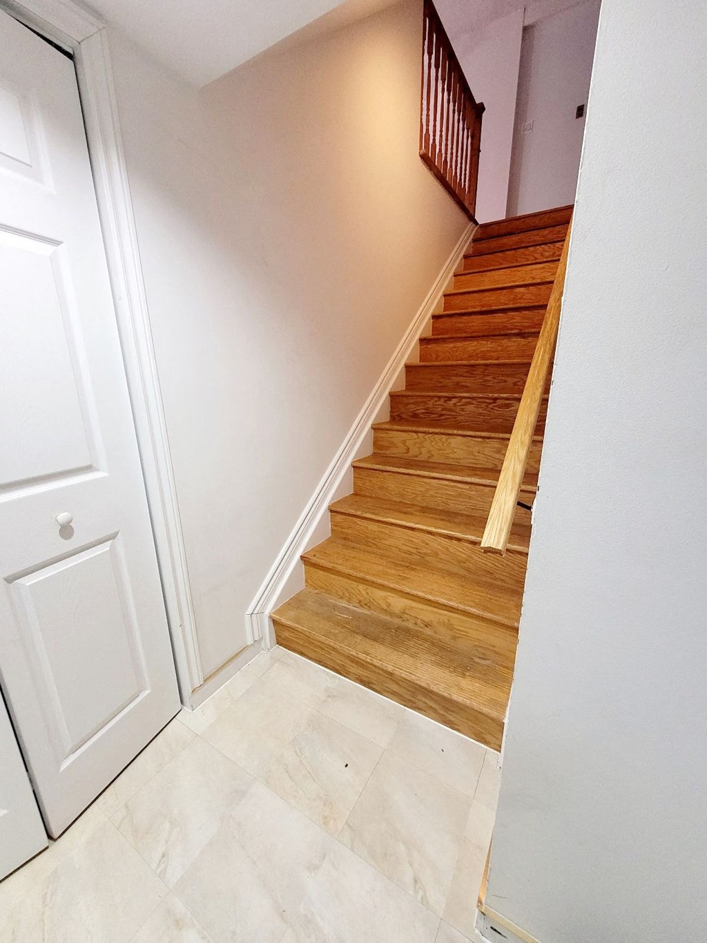 A staircase with wooden steps and a white door.