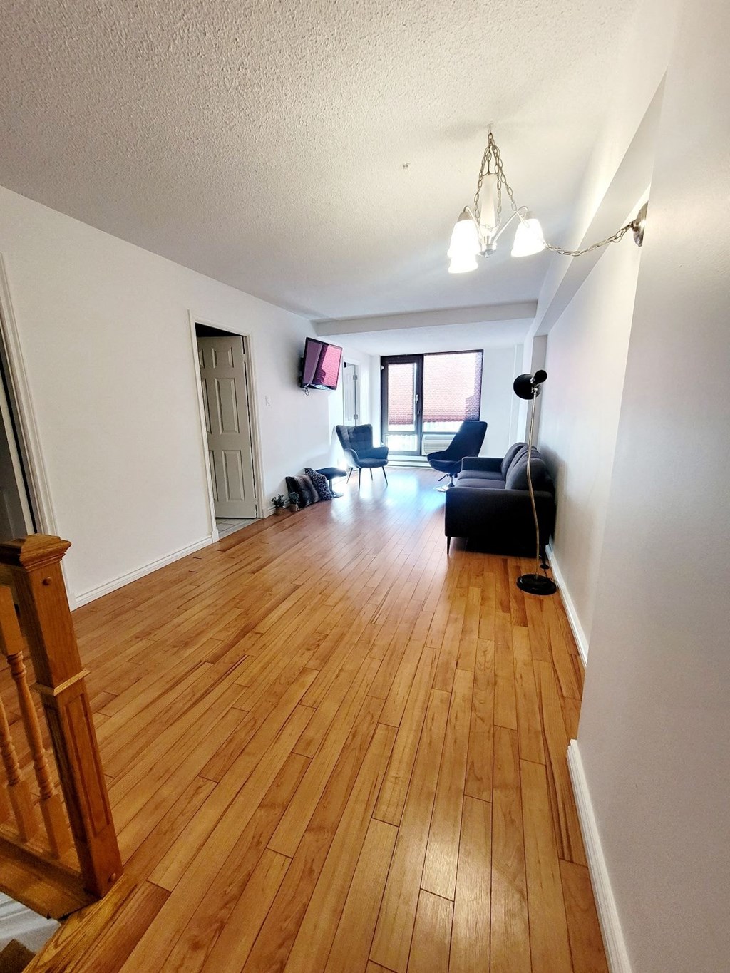 A room with wooden floors and a black couch.