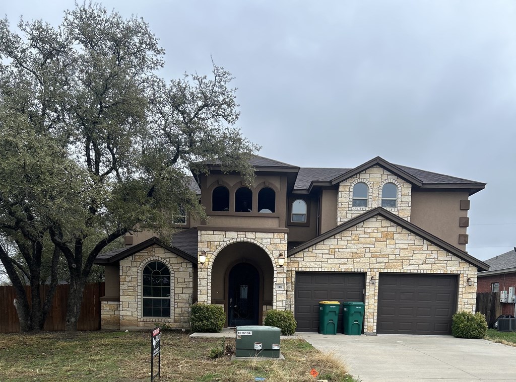 A house with a stone facade and a black garage door.