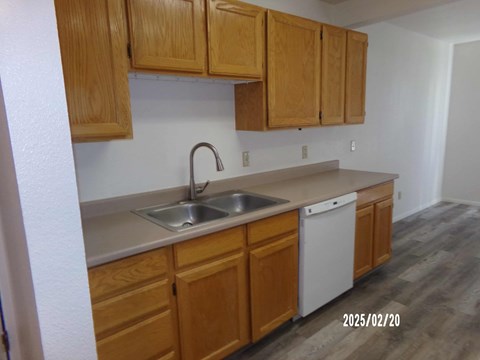 A kitchen with wooden cabinets and a white dishwasher.