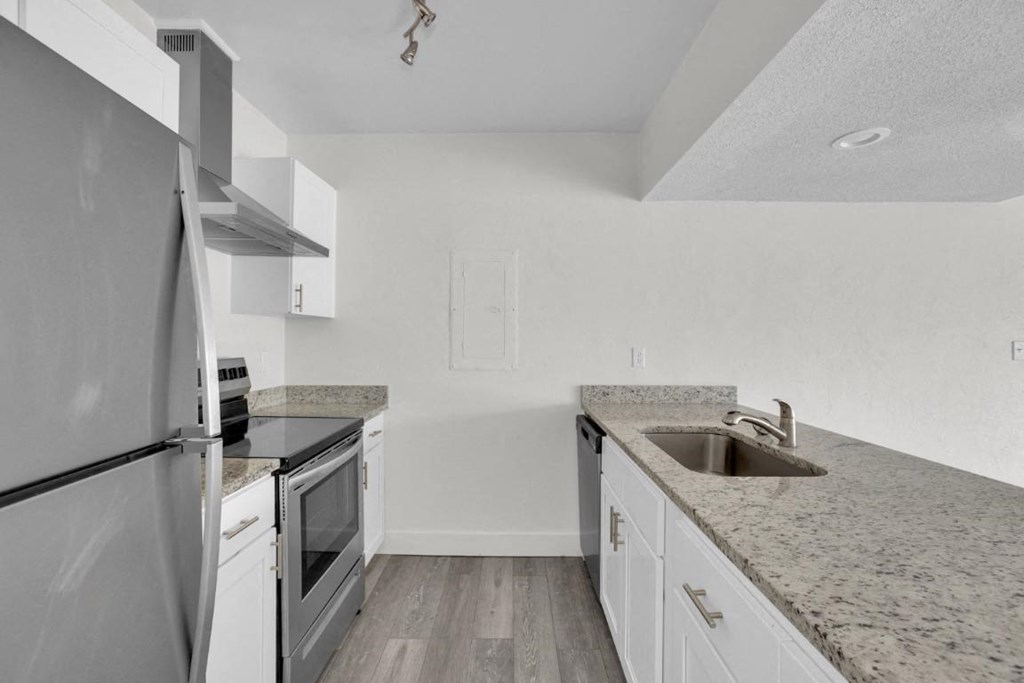 A kitchen with a granite countertop and stainless steel appliances.