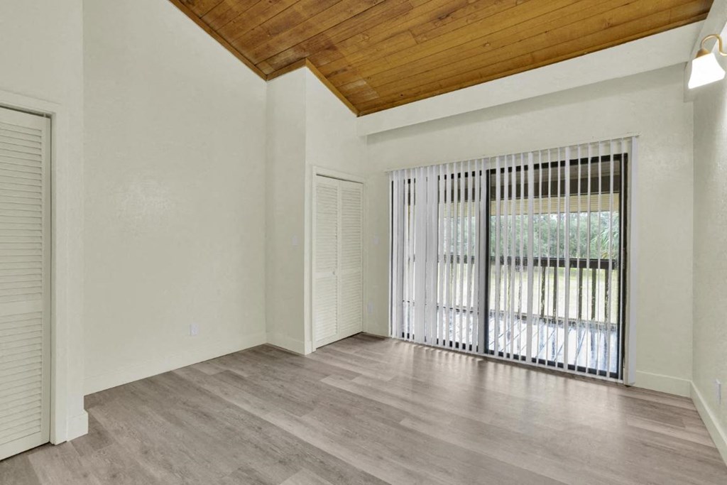 A room with a sliding door and a wooden ceiling.
