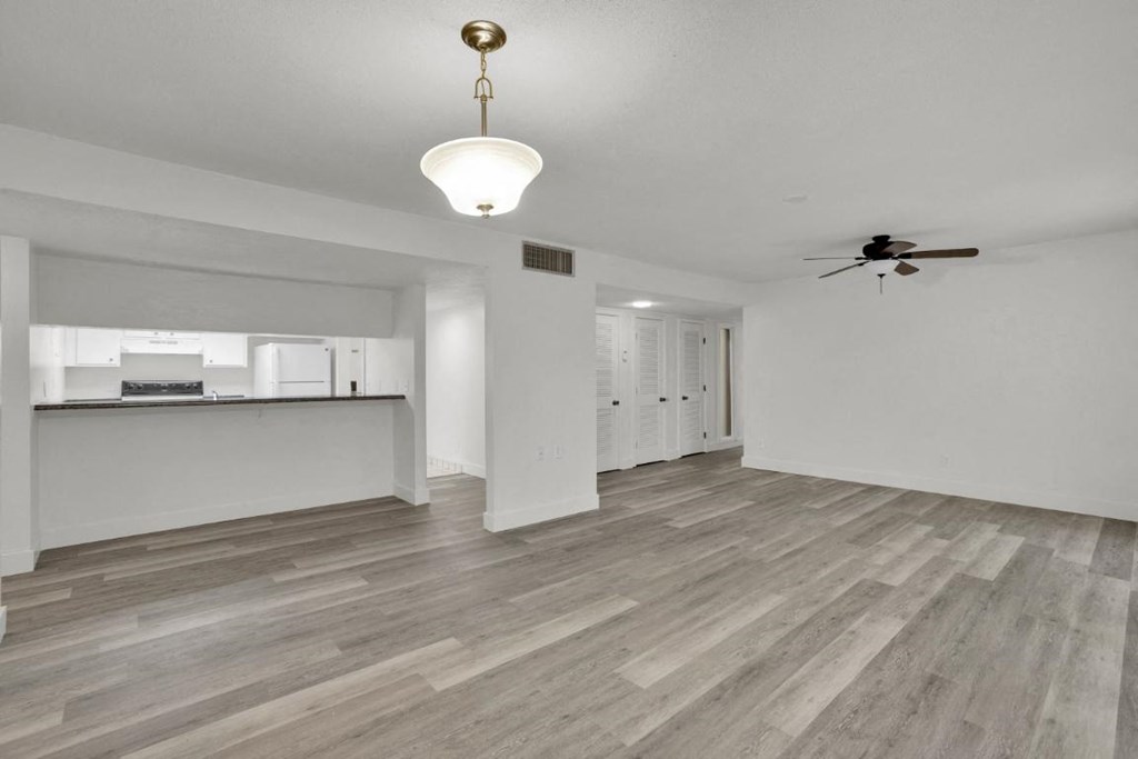 A room with a ceiling fan and a light hanging from the ceiling.