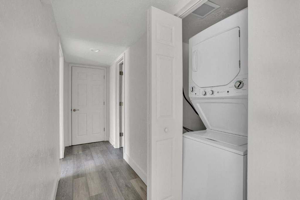 A white washing machine is in a small laundry room.