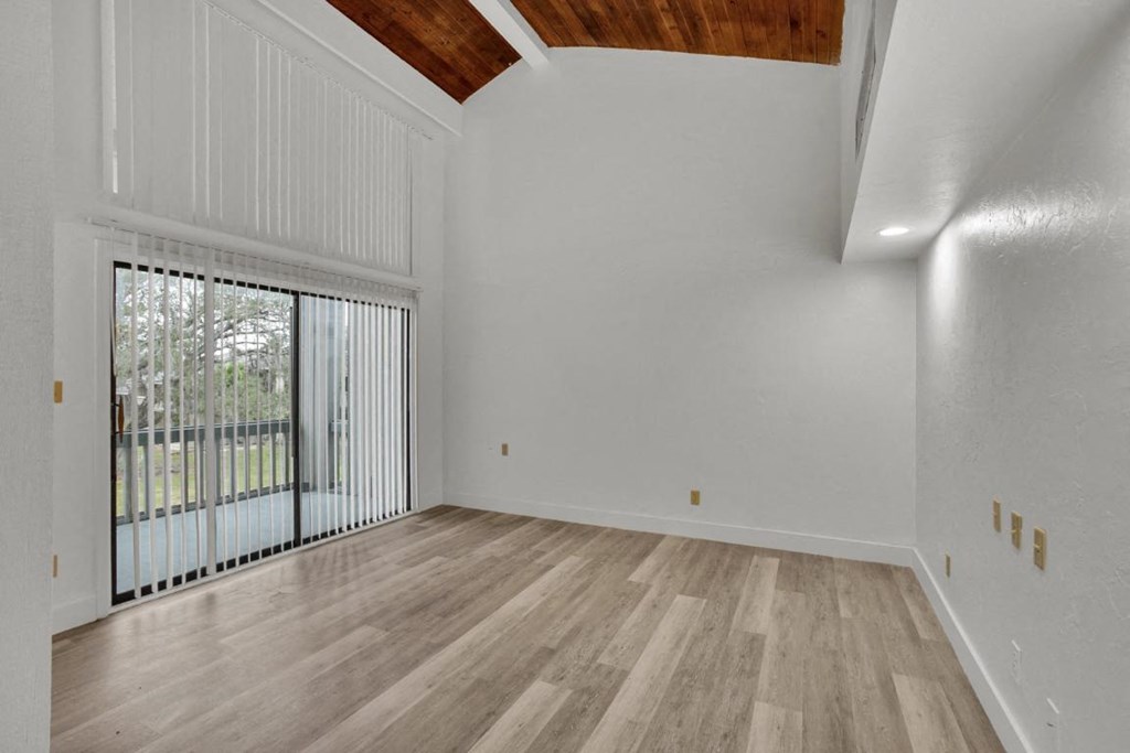 A room with wooden flooring and white walls.