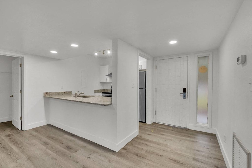 A white room with a counter and a door.