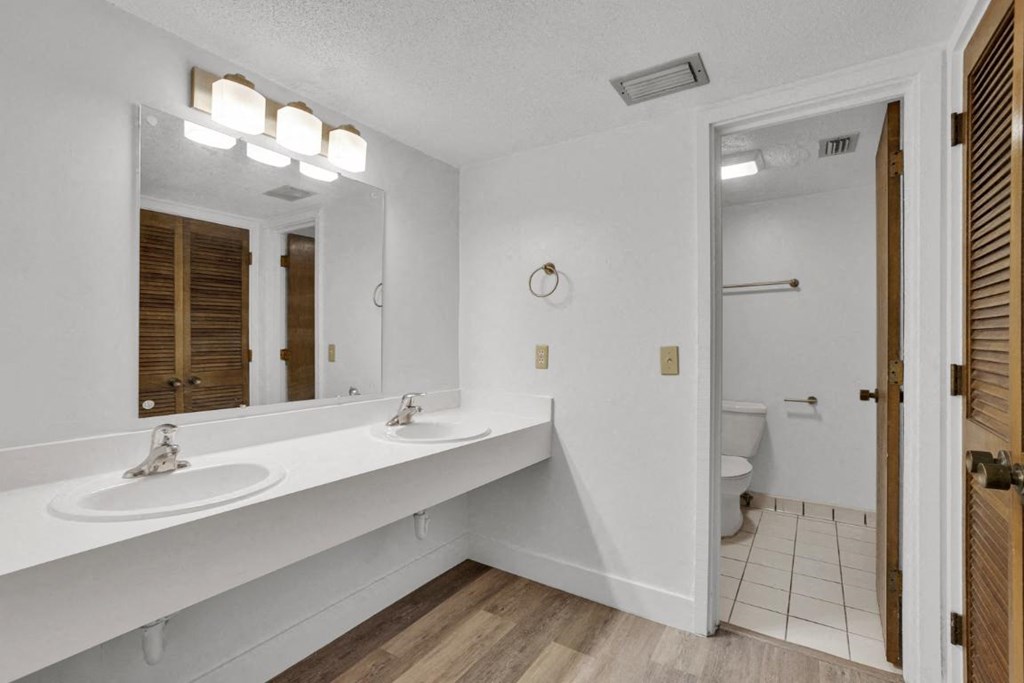 A bathroom with a white sink and mirror.