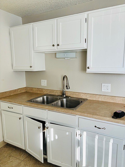 A kitchen with white cabinets and a granite countertop.